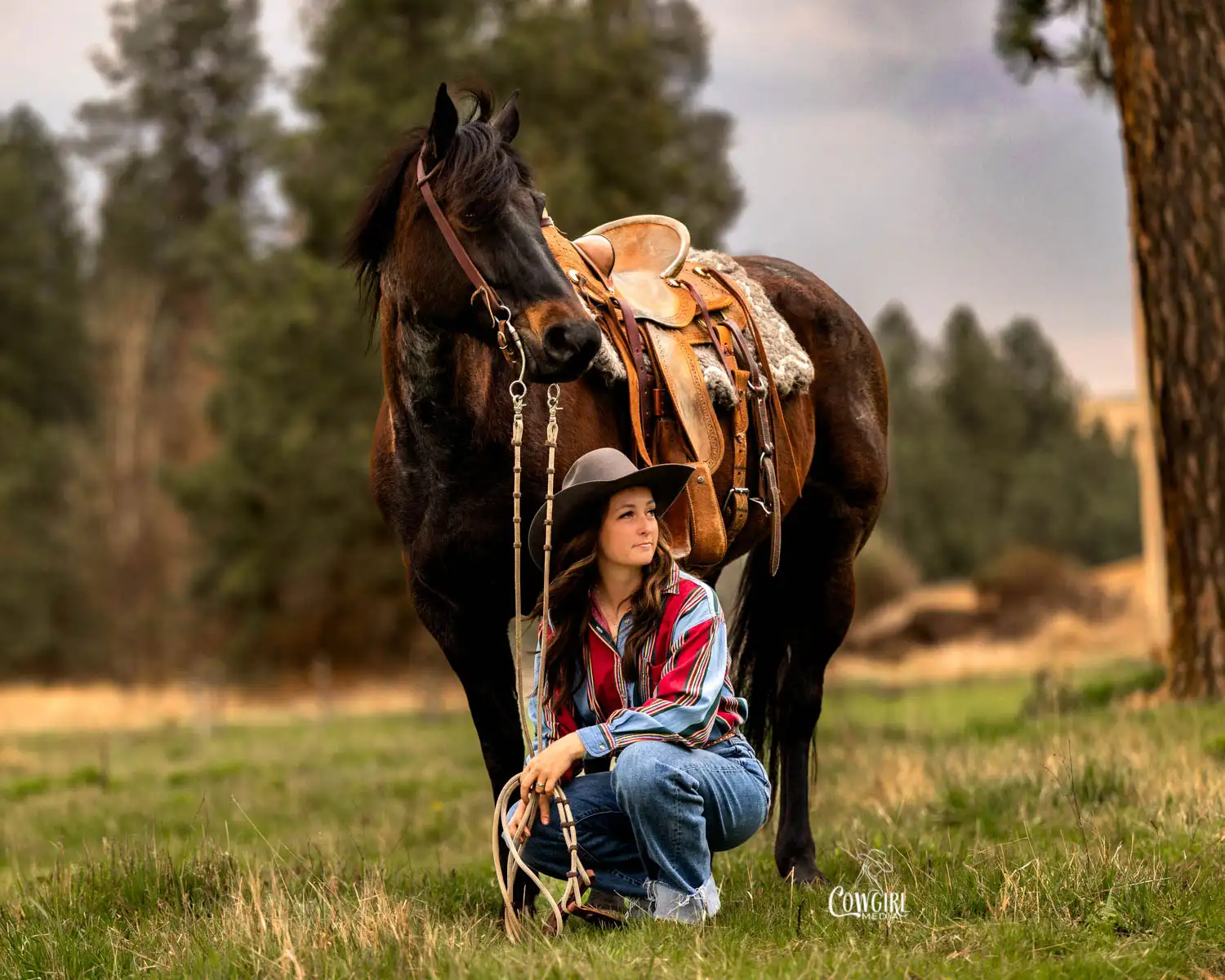 cowgirl with horse in a lush green pasture during an equine photo session in Kendrick, ID