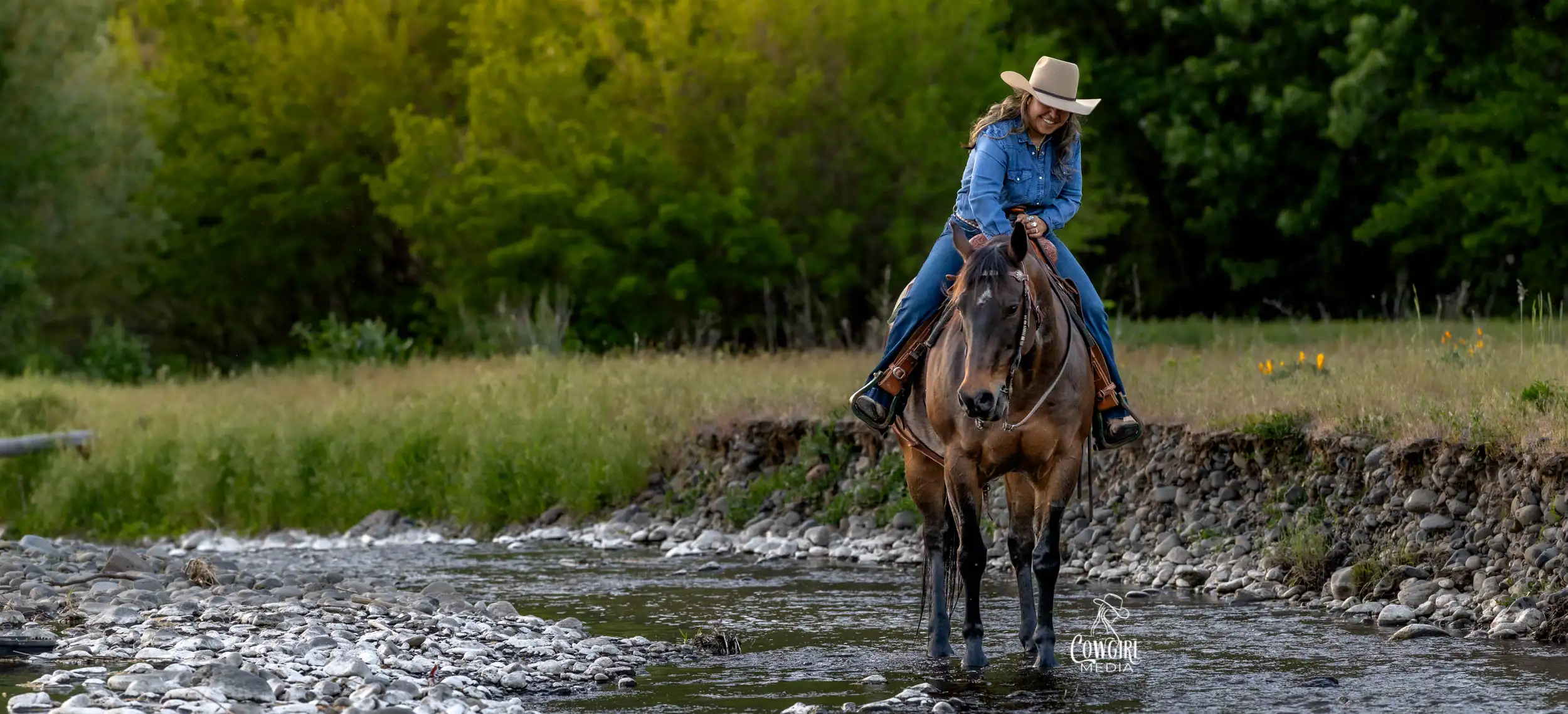 Woman riding her horse in the creek