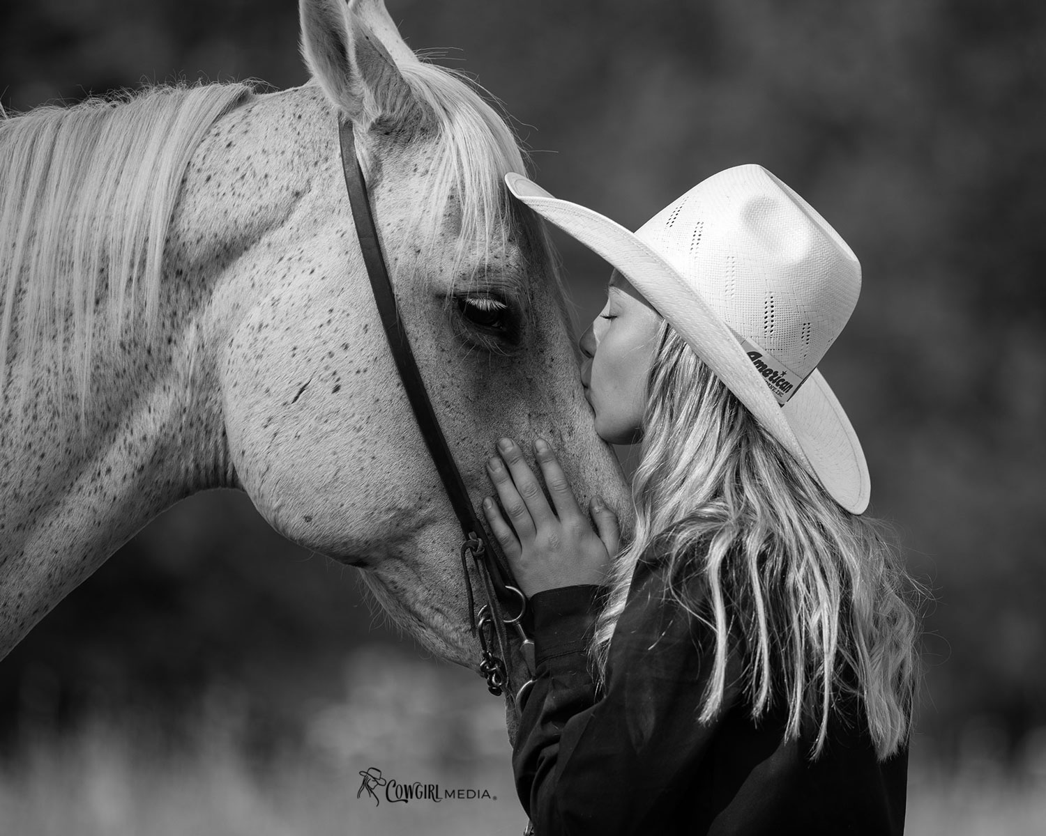 Young cowgirl kissing her trusted senior horse during an equine end-of-life photo session